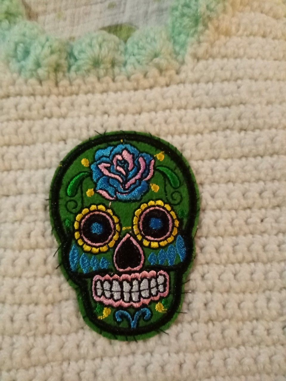 Hand-knitted sugar skull baby bib