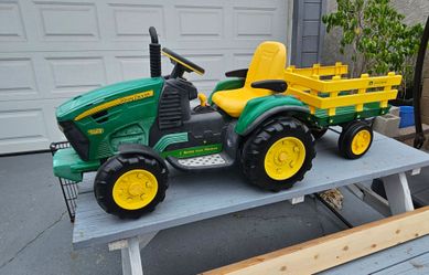 Kids John Deere Ground Force 12V Ride-On Tractor with Trailer, and it is manufactured by Peg Perego., Good condition, brand new charger, Normal wear