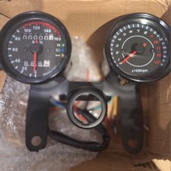  universal 12V motorcycle speedometer and tachometer gauge cluster. 
 Includes an LED backlight, a mechanical speedometer, and a digital LED odometer/