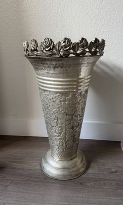 ornate silverplate or sterling silver repoussé vase with a floral rim and chased designs.  