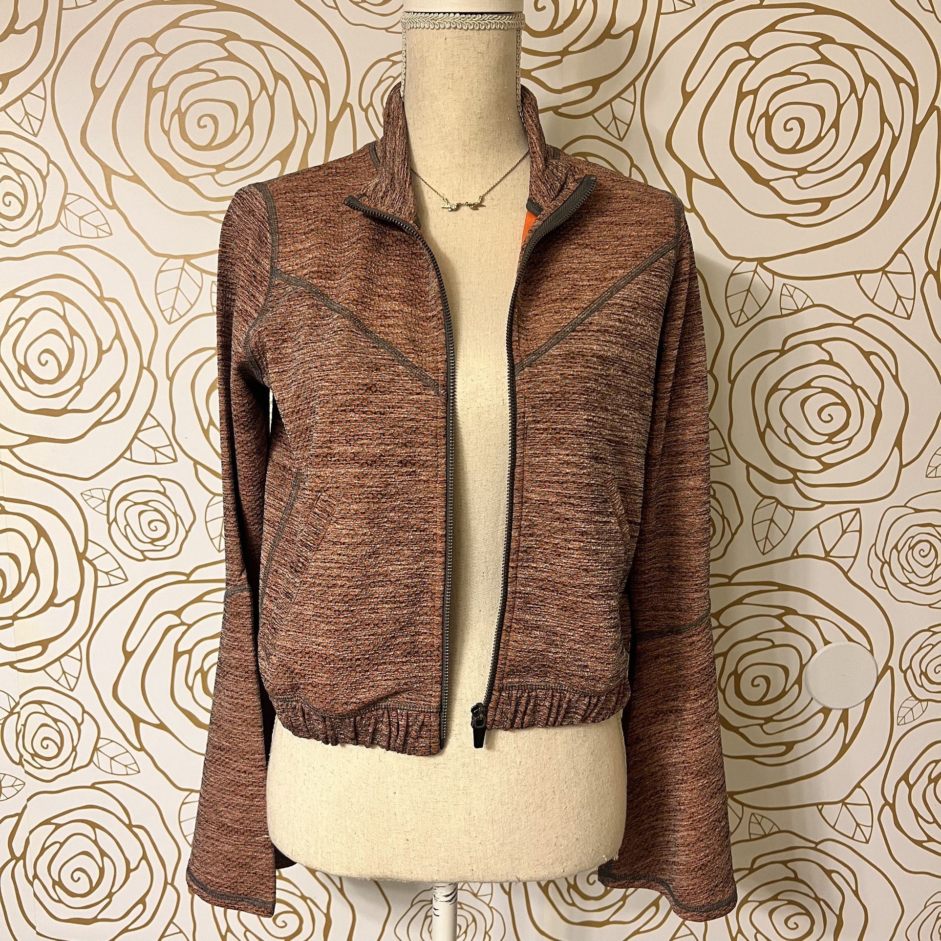 Free People Movement "Off The Grid" textured bell sleeve jacket in orange rust and gray.