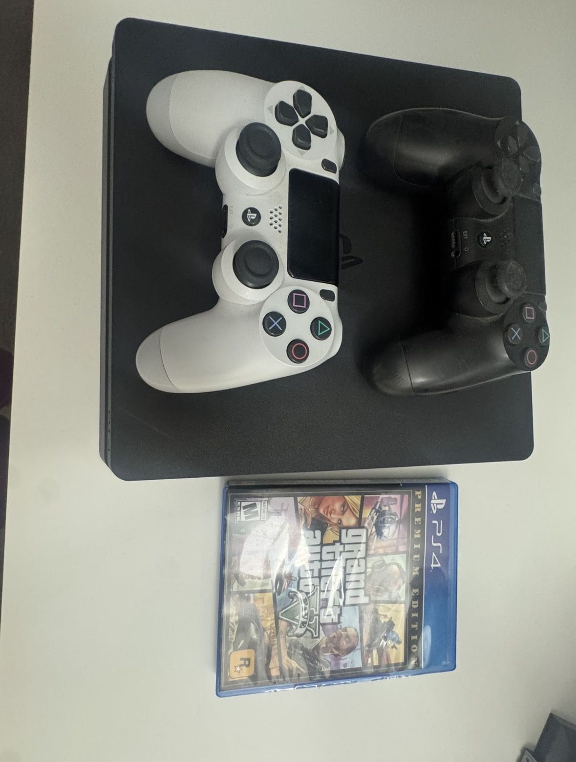 PlayStation 4 Slim - Includes GTA 5 Disc, Black Controller, White Controller