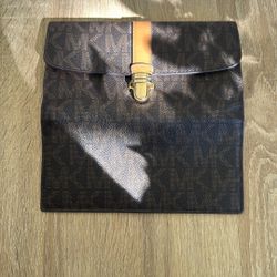 Michael Kors wallet — specifically a Michael Kors monogram zip or flap wallet.