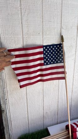 This is an 8" x 12"S. flag made in the U.S.A. [1]The product features a classic red and white striped design, as shown by the barcode label
