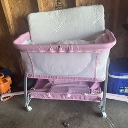 Pink and white bassinet