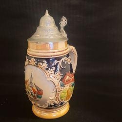 Vintage German beer stein hand-painted ceramic body pewter lid 
SCHROBENHAUSEN LENBACHSTADT. It  is topped with a traditional hinged 
pewter lid. 7 3/