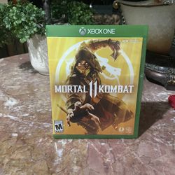 The image shows a physical copy of the Mortal Kombat 11 video game for the Microsoft Xbox One console. 