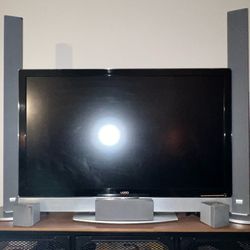 FLATSCREEN VIZIO TV WITH SOUND BAR AND SURROUND SOUND SYSTEM