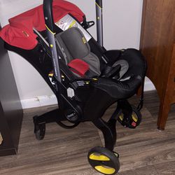 A Red  Doona Car Seat Stroller With Base