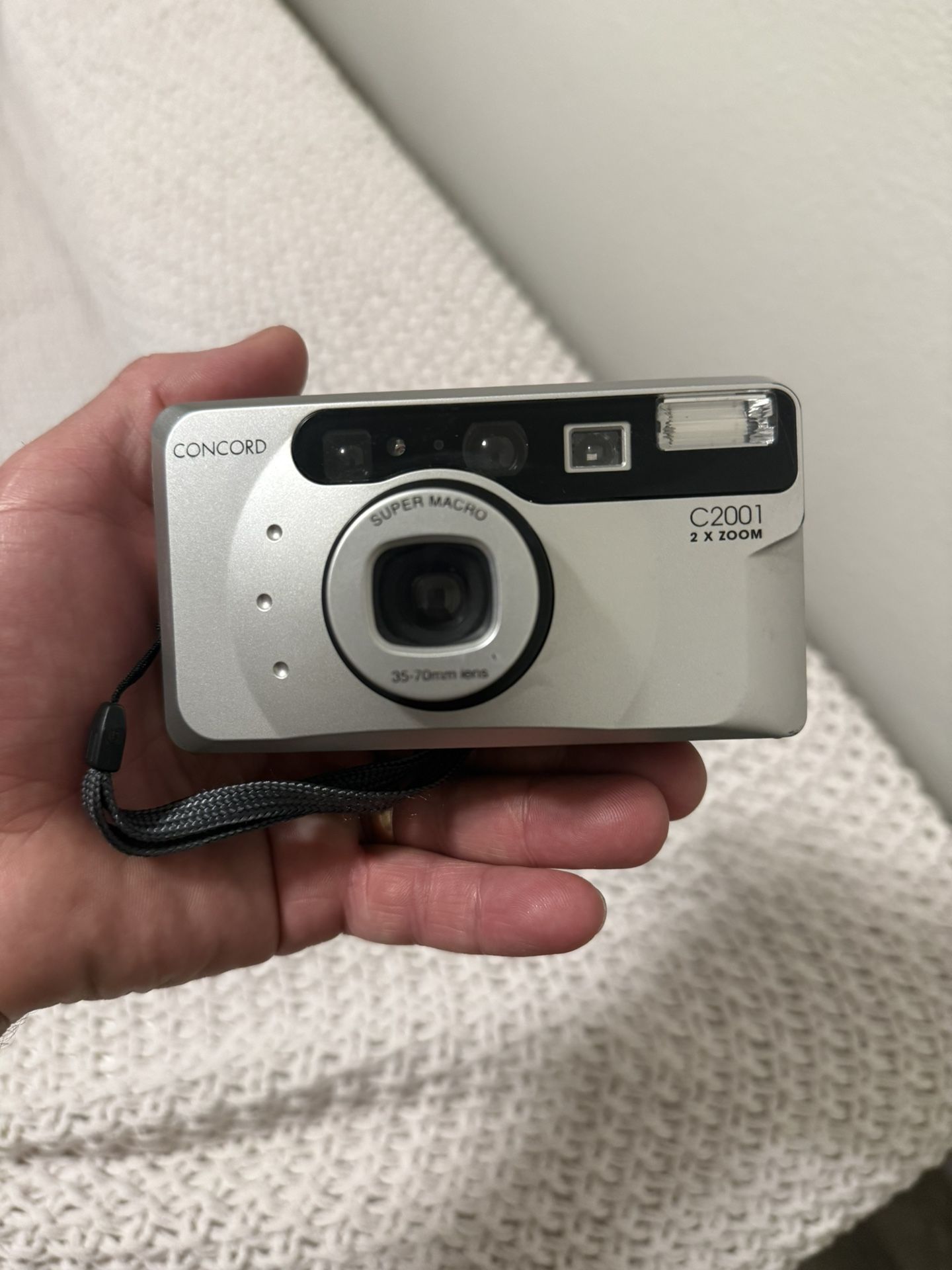 This is a Concord C2001 35mm film camera. Equipped with a 35-70mm zoom lens with autofocus. Has a "Super Macro" function for detailed close-up shots.