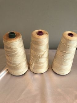 3 white sewing machine threads