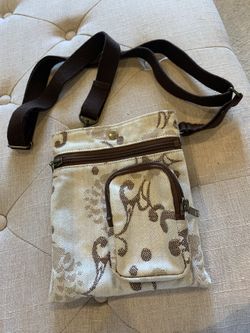 Beige and brown floral crossbody bag with adjustable strap and multiple pockets