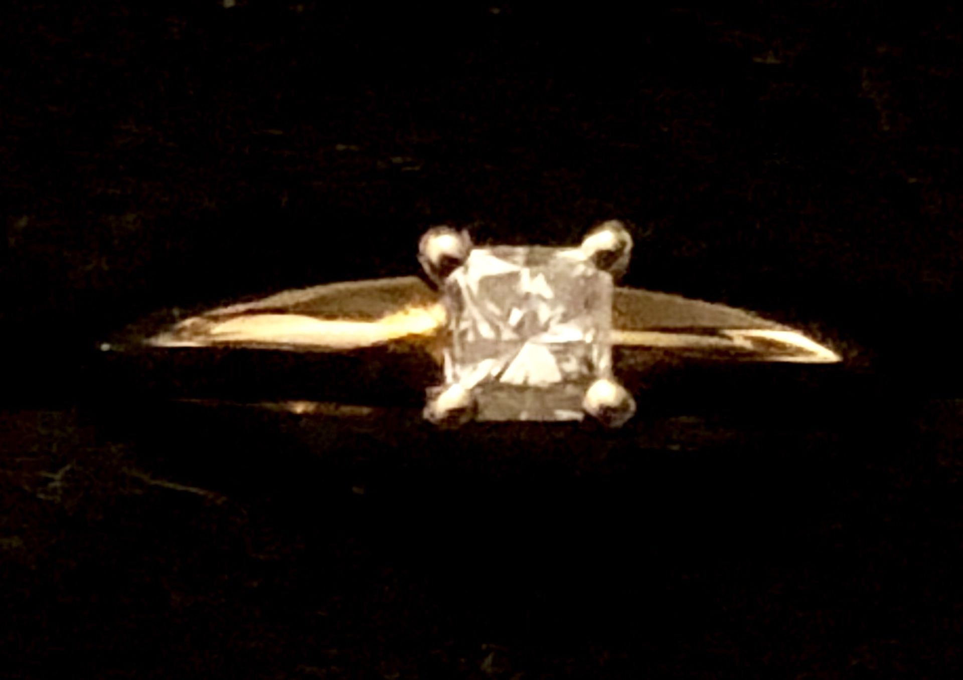 Princess cut diamond ring set in 14 karat gold Tiffany setting