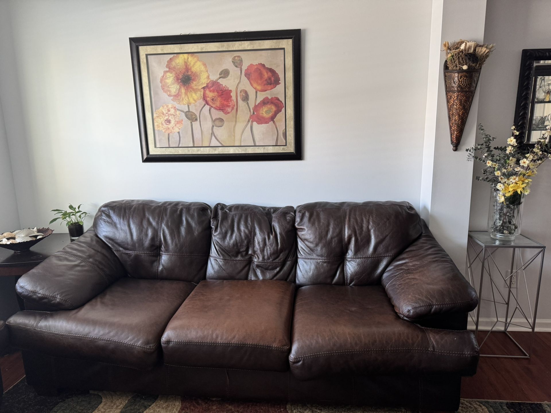 Two leathers sofas with love sit and area rug.