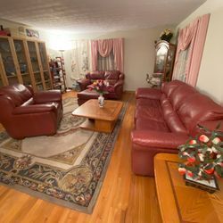 A Seven-Piece Living Room Set Including A Red Leather Sofa, A Leather Love Seat, A Leather Chair, A Leather Ottomans, A Coffee Tabor And Two End Table