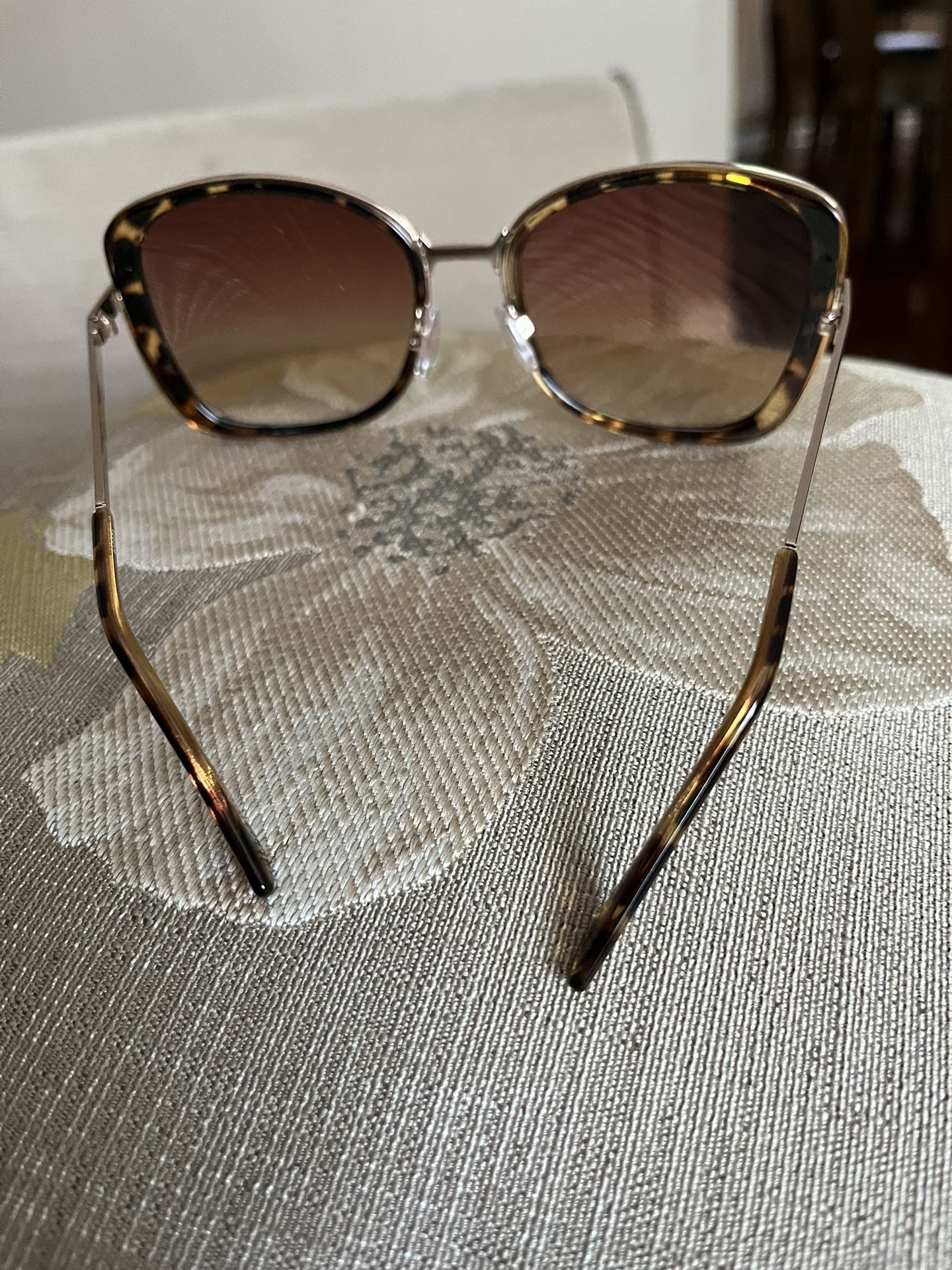 There A Beautiful Sunglasses For Women’s Made By You Can HIDE BEHIND Me If You Want To The Color Is Brown With Gold Around It