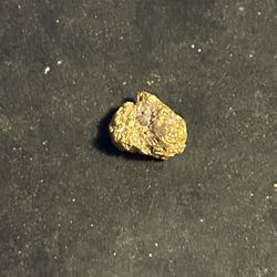 A solid gram of gold with quartz in it laying at 1.2 g