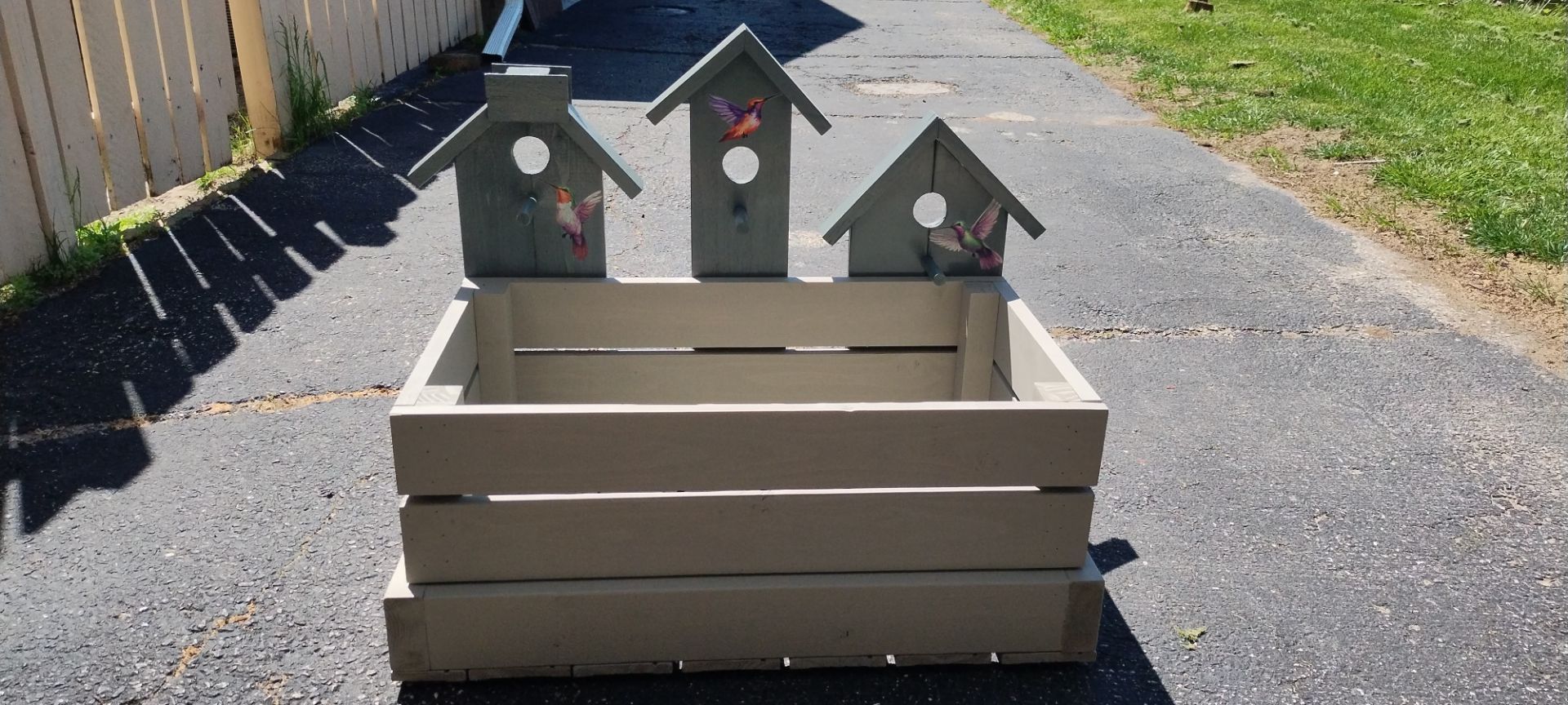 Wooden planter box with birdhouses.