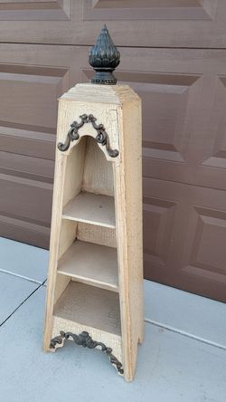 43" Tiered Decorative Display Shelf Stand 
Features a cream-colored, crackled paint finish with dark metal decorative elements.
Structure: Tapered for