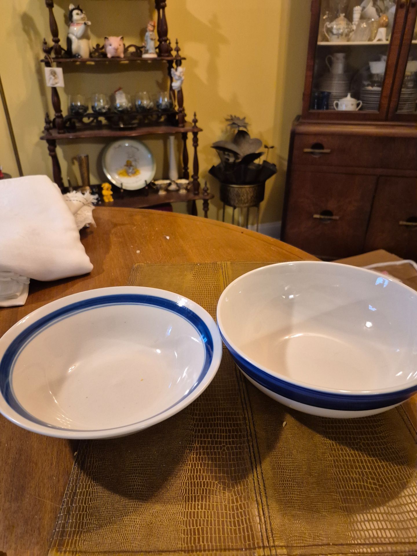 2 9" stoneware bowls with blue stripe around the top one bowl is slightly larger than the other Bowl
