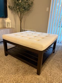 Square beige ottoman coffee table - used for staging.