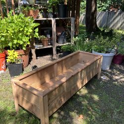  A container made of cedar wood designed for planting flowers & More.