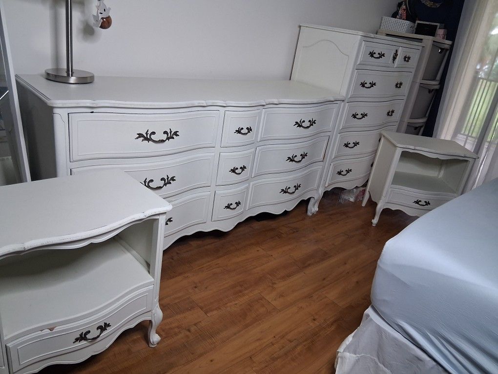 vintage-style 4-piece bedroom set made of solid white wood. The set includes a 5-drawer chest, a 9-drawer dresser, and two nightstands with one drawer