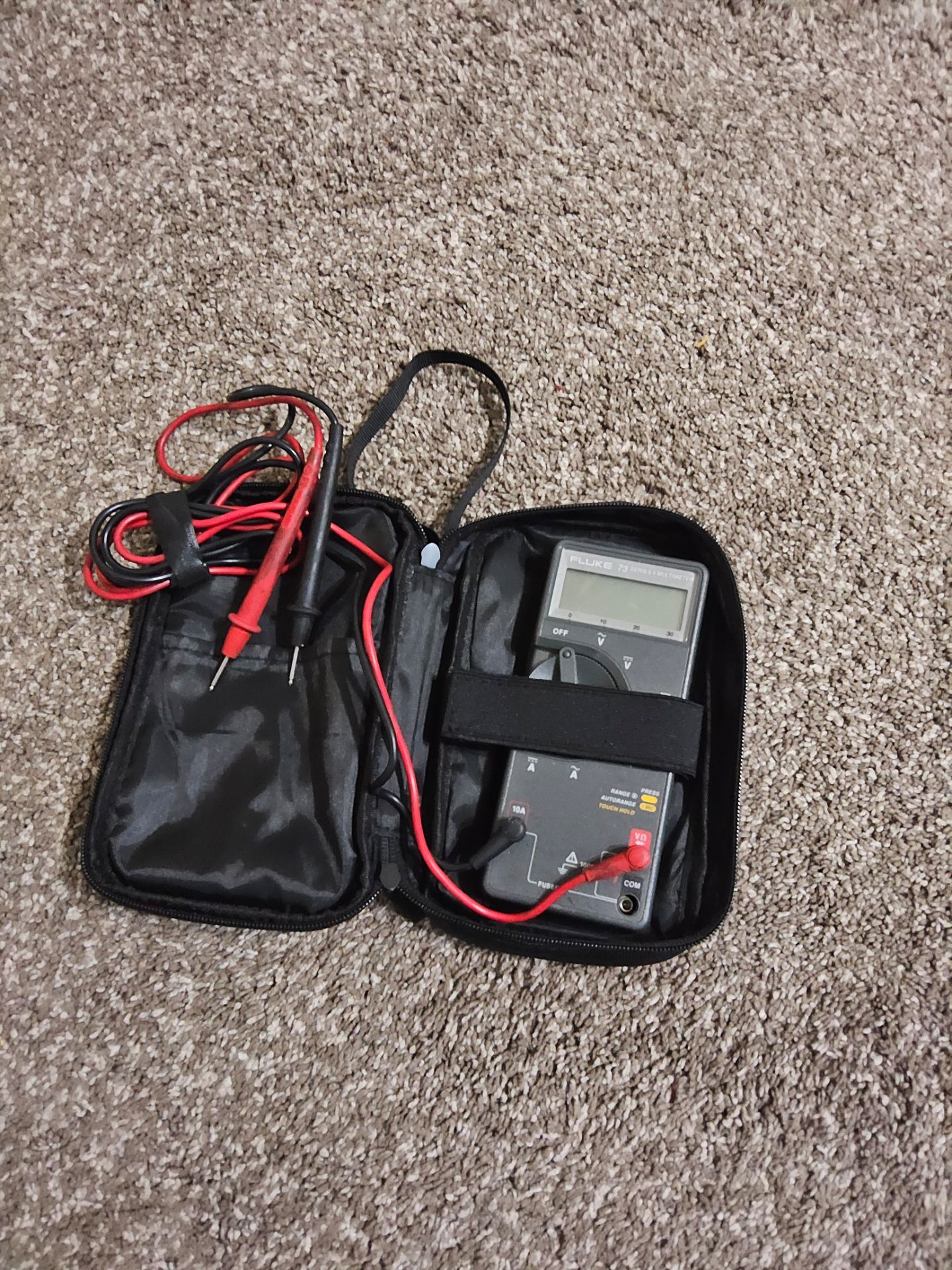 Fluke 73 Series III handheld digital multimeter with test leads in a carrying case.
