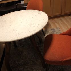 Marble Top Dining Table With 2 Fabric Orange Chairs. 