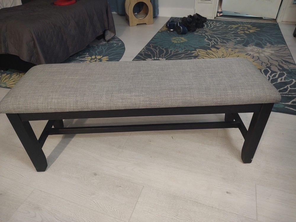Bench with a gray cushion black legs 15 inches width x 47 length x 19 inches height