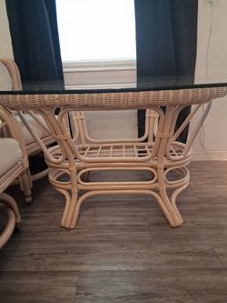 Vintage Rattan dining set.  Glass top table in mint condition.  4 kings chairs on wheels.