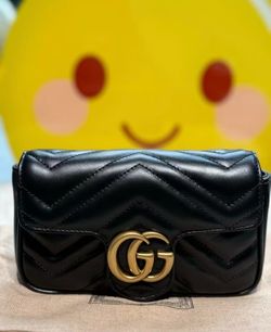Gucci black Mammon chain crossbody bag on one shoulder
