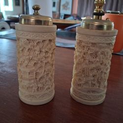 Vintage carved faux ivory salt and pepper shakers, frequently made from composite materials or resin to simulate the look of carved bone or ivory. 