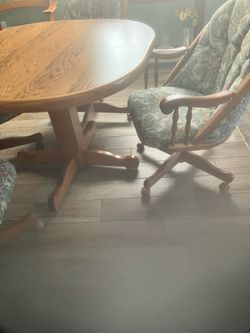 Dining table and 4 upholstered swivel chairs with a leaf