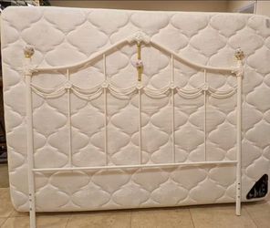 Queen cream colored pillow top mattress & box spring with cream decorative metal headboard and bed frame.