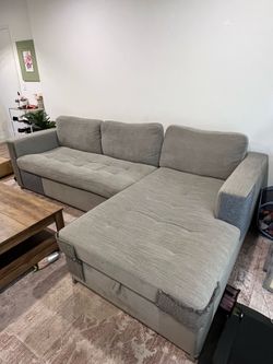 Grey sectional sofa w/ pullout bed + storage chaise
