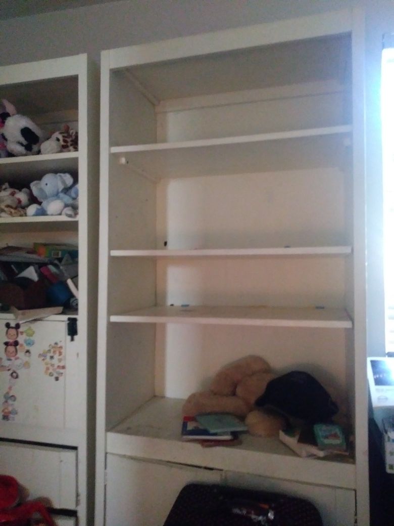 Sturdy white bookcase with bottom storeage .