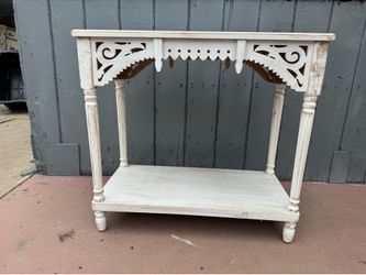 Rectangular console table is constructed using fir and manufactured wood. Console and entry table has a decorative scroll front. Table has a slightly