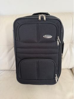 black Ciao! Sport upright suitcase features a silver brand plaque and multiple zippered front pockets.
