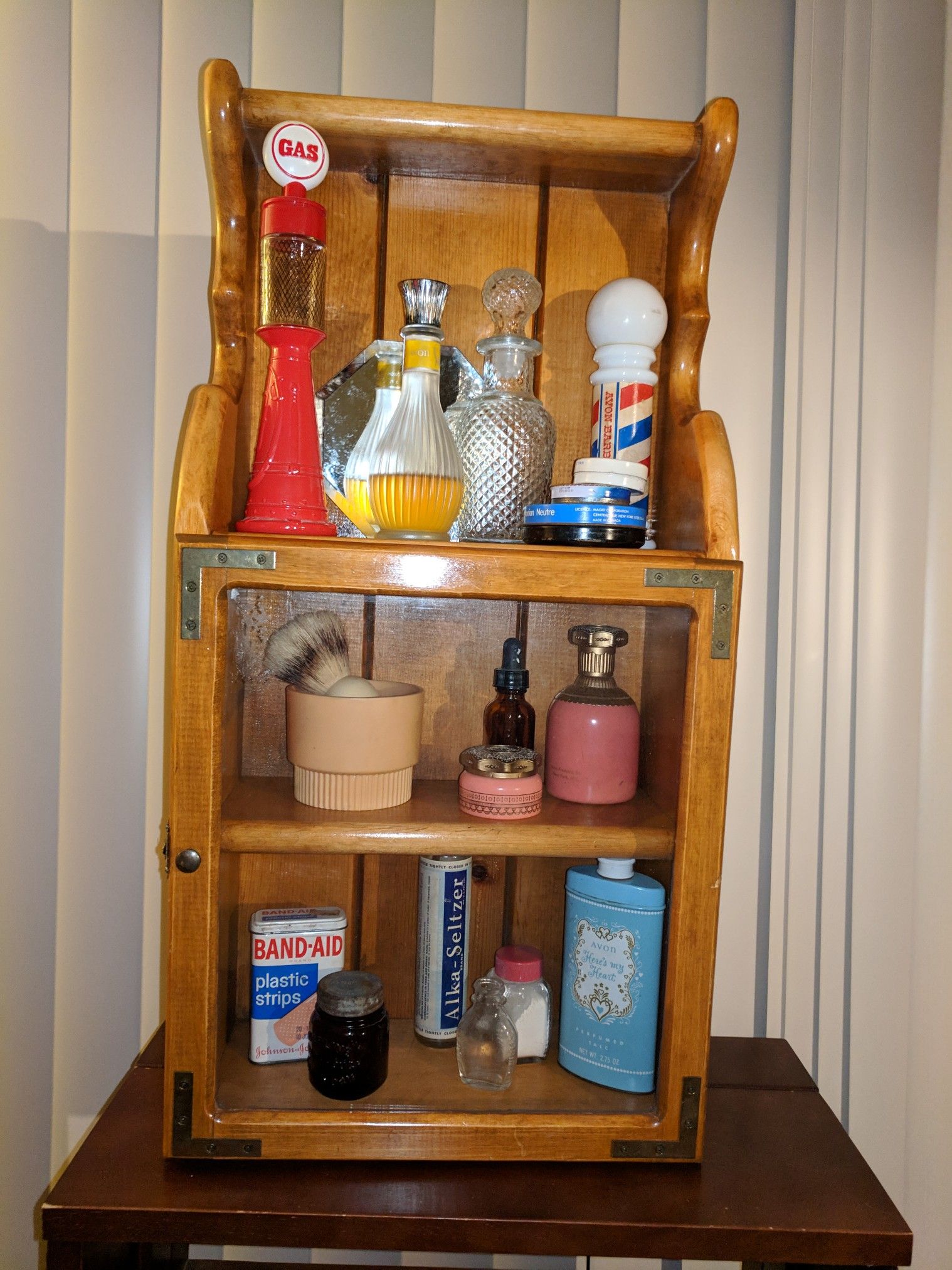 Old fashioned medicine cabinet with collectible vintage Avon and other brand name antique bottles.