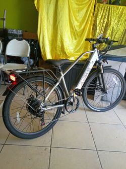 Aipas C2 Xpress Electric Bike, featuring a sleek silver frame, front suspension, and a rear cargo rack.Performance: Equipped with a 750W motor and a r