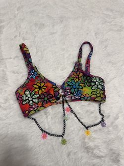 Vibrant crop top covered in colorful smiley faces. Thin straps and front knot detail. Decorative black chain with multicolor smile charms. Fun, playfu