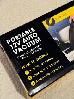 New in Box Portable 12V Car Auto Vacuum Compact portable auto vacuum is black and powered by a 12V socket. It has two crevice tools and an easy-clea