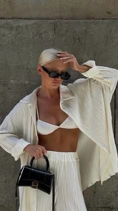 A white pleated pantsuit with an oversized long shirt.