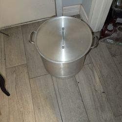 


+4
This item is a large aluminum stockpot with a lid, commonly used for boiling, steaming, or frying. 