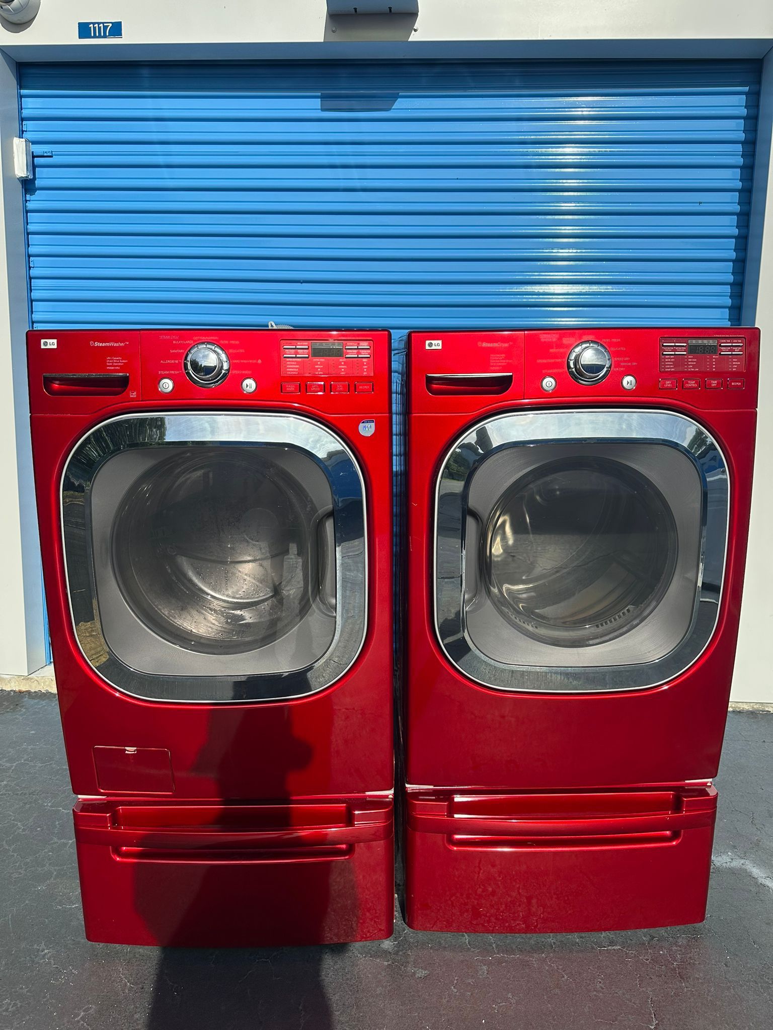 LG front-loading washer and dryer set with extra-capacity red pedestal