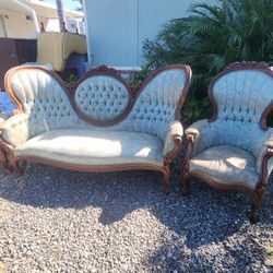 This is a Victorian-style parlor settee and matching armchairs, likely featuring a mahogany frame with carved details and blue tufted fabric upholster
