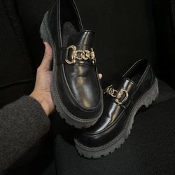 Black leather loafers with gold chain detail 