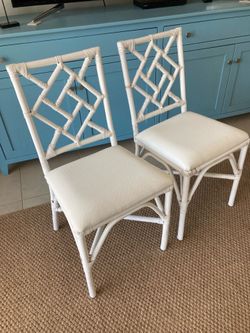 Two white rattan chairs