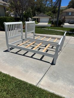 Two white wooden twin bed frames